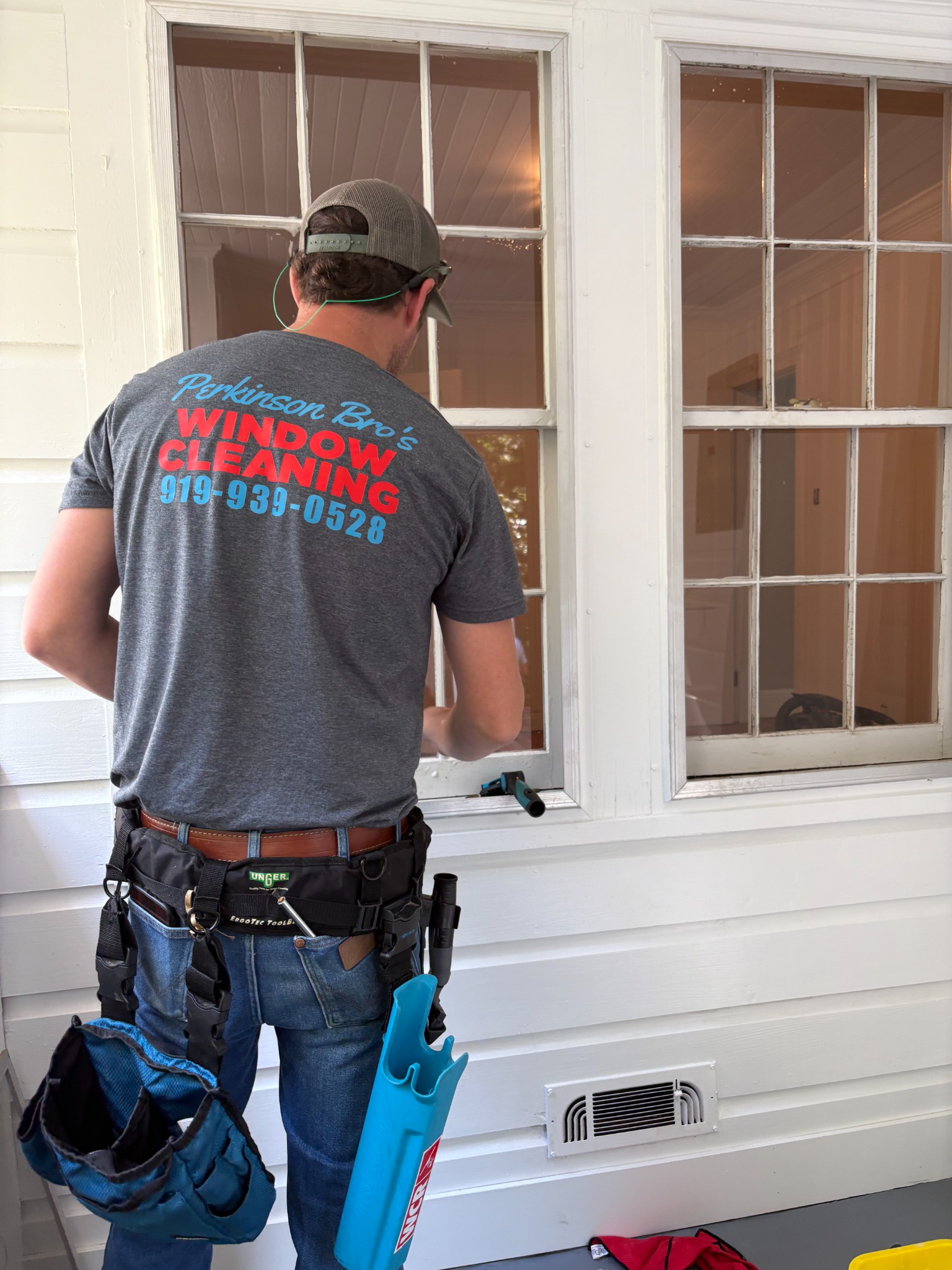 Perkinson Bros technician cleaning residential windows